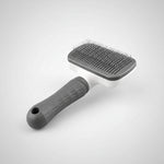 Pet grooming brush with text highlighting features on a white background